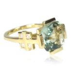 A gold ring with a green stone and crosses on it.
