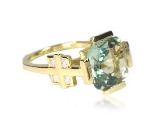 A gold ring with a green stone and crosses on it.