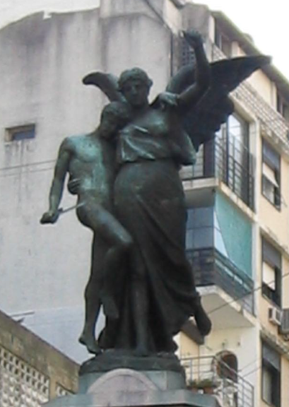 Angel statue with buildings in background.